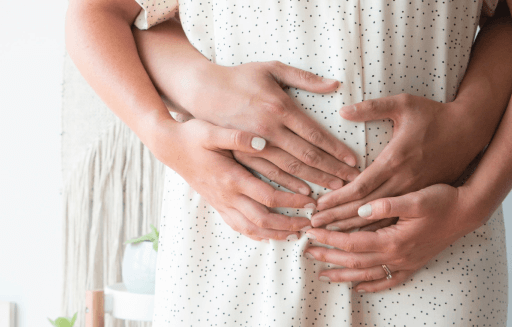 Prather-Infertility 1 Person holding their stomach with another's arms holding them from behind.