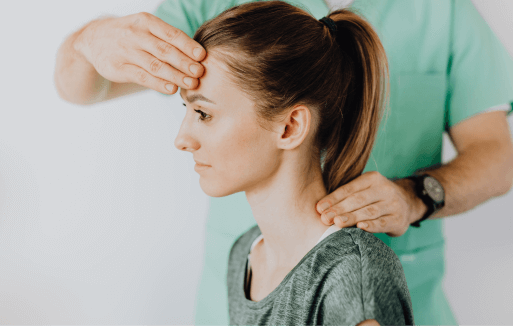 Prather-Whiplash 2 Chiropractor holding the back of a patient's neck and their forehead.