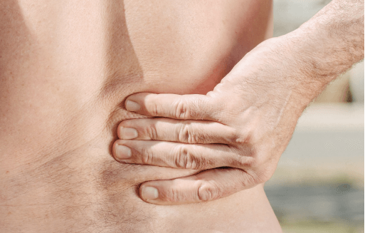 Prather-Lower Back Pain 1 Shirtless person holding their low back.