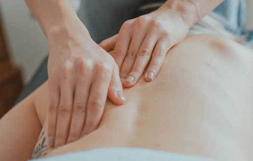 Prather-Herniated Discs 2 Chiropractor palpating a patient's bare back.